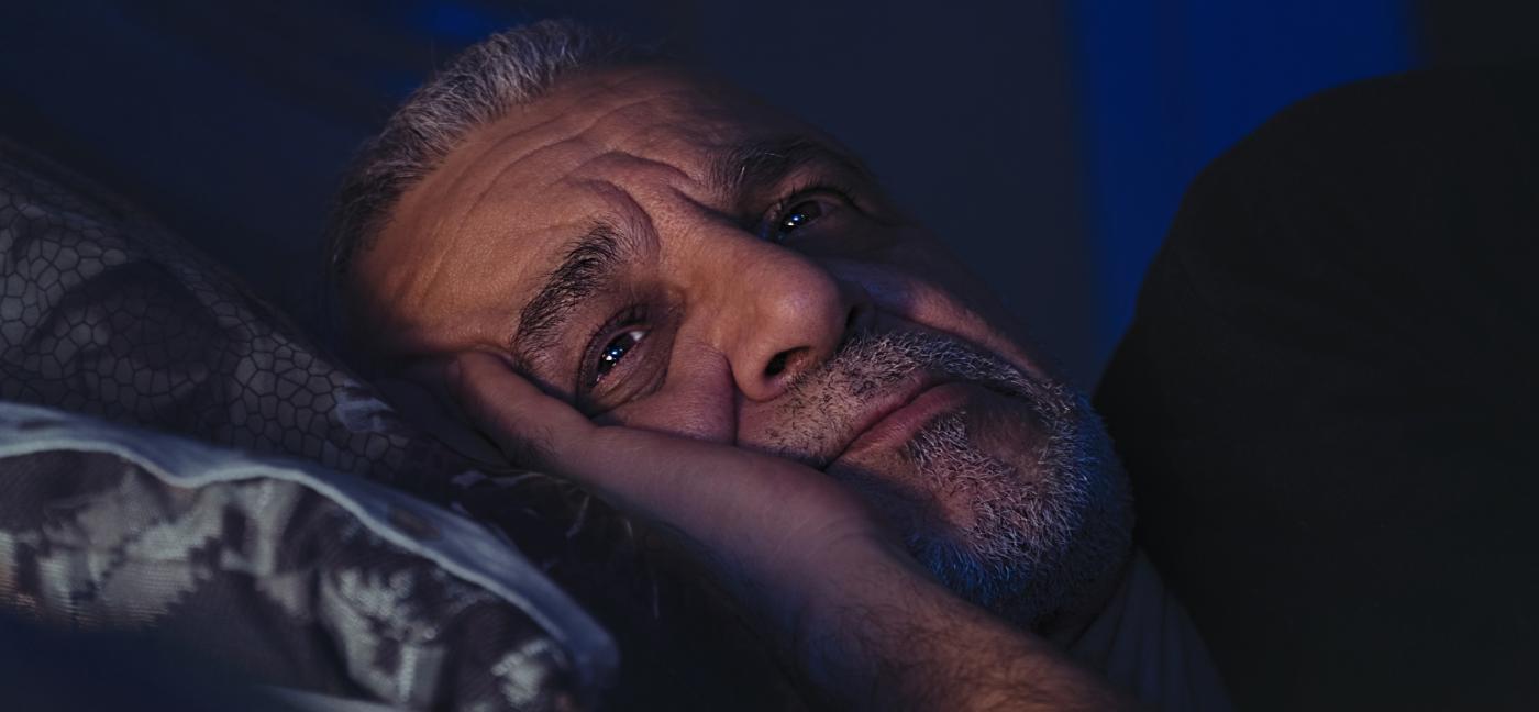 Older man awake in bed