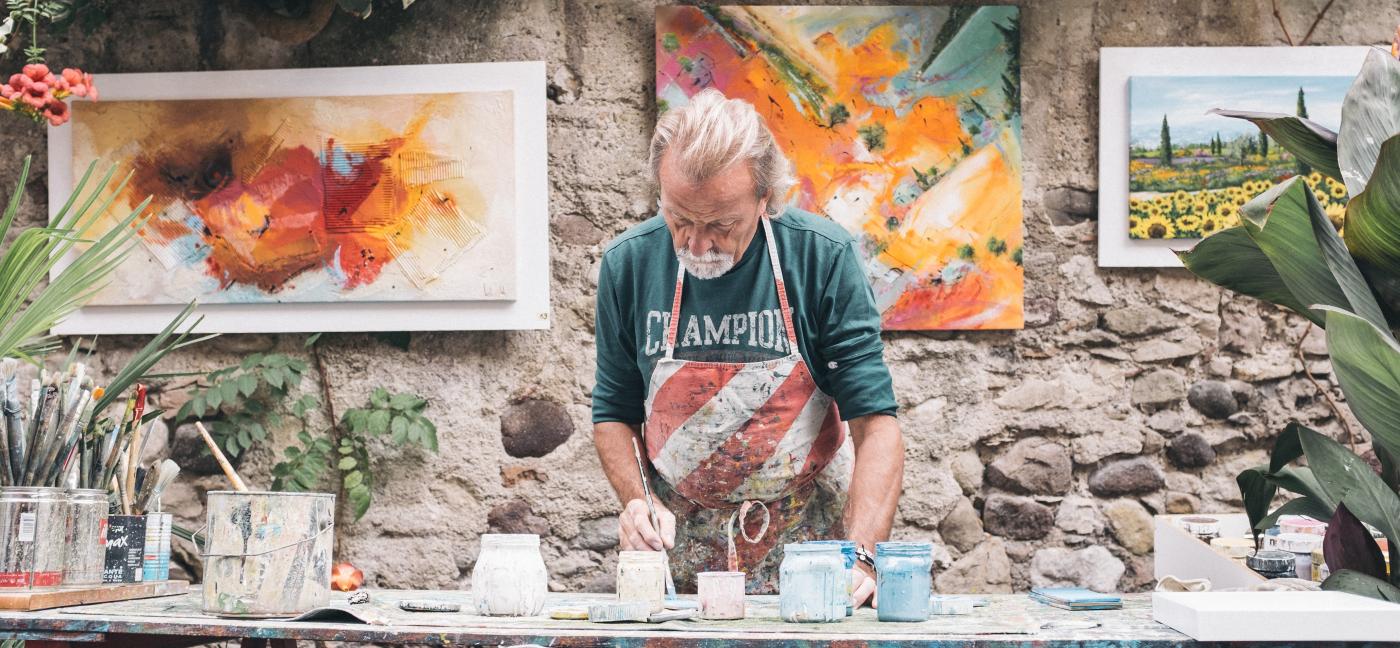 older man painting at table