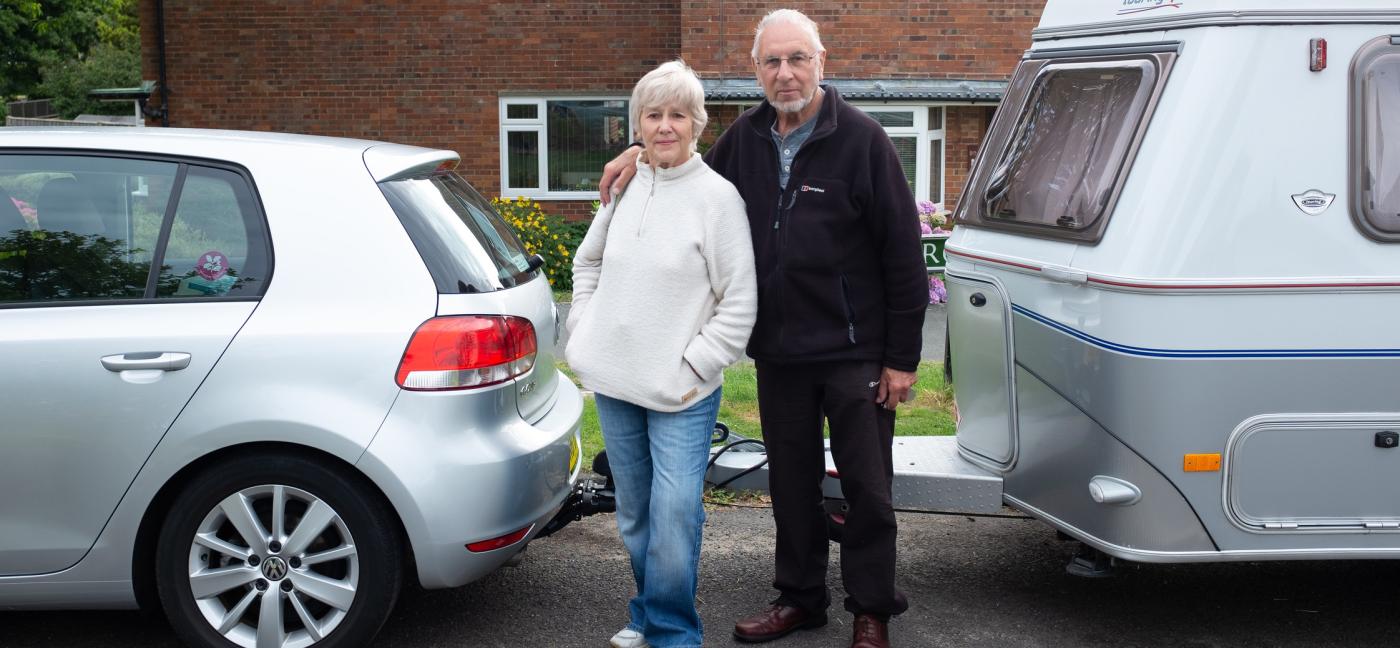 Older man and woman outside house