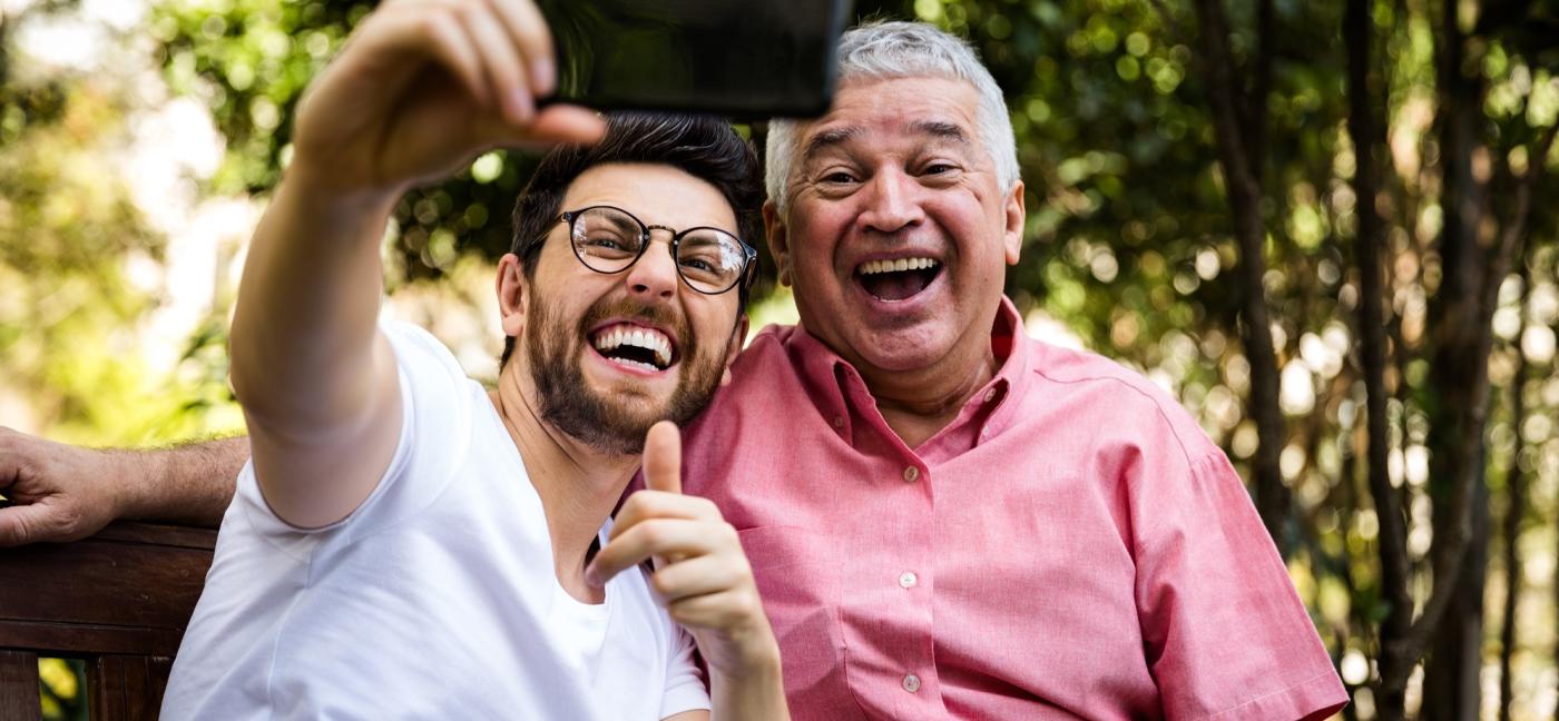 older and younger man taking selfie