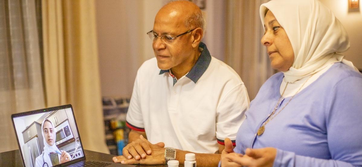 Arab doctor consulting virtually with older couple