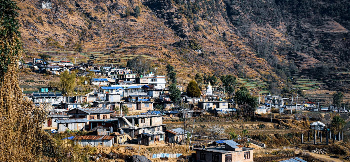 A small mountain village in Nepal with houses scattered along terraced hillsides.
