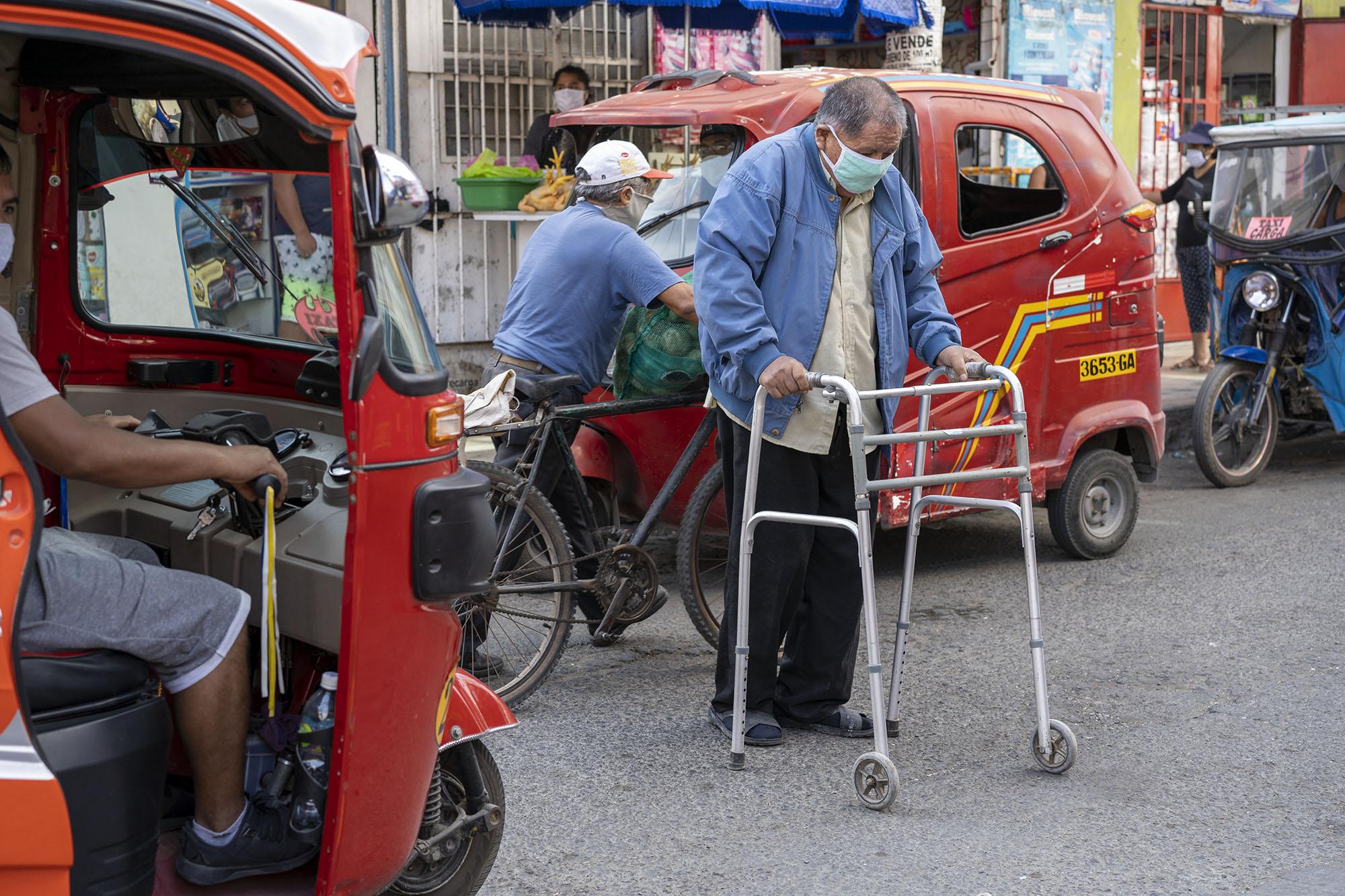 Older adult with walker crosses street in Peru