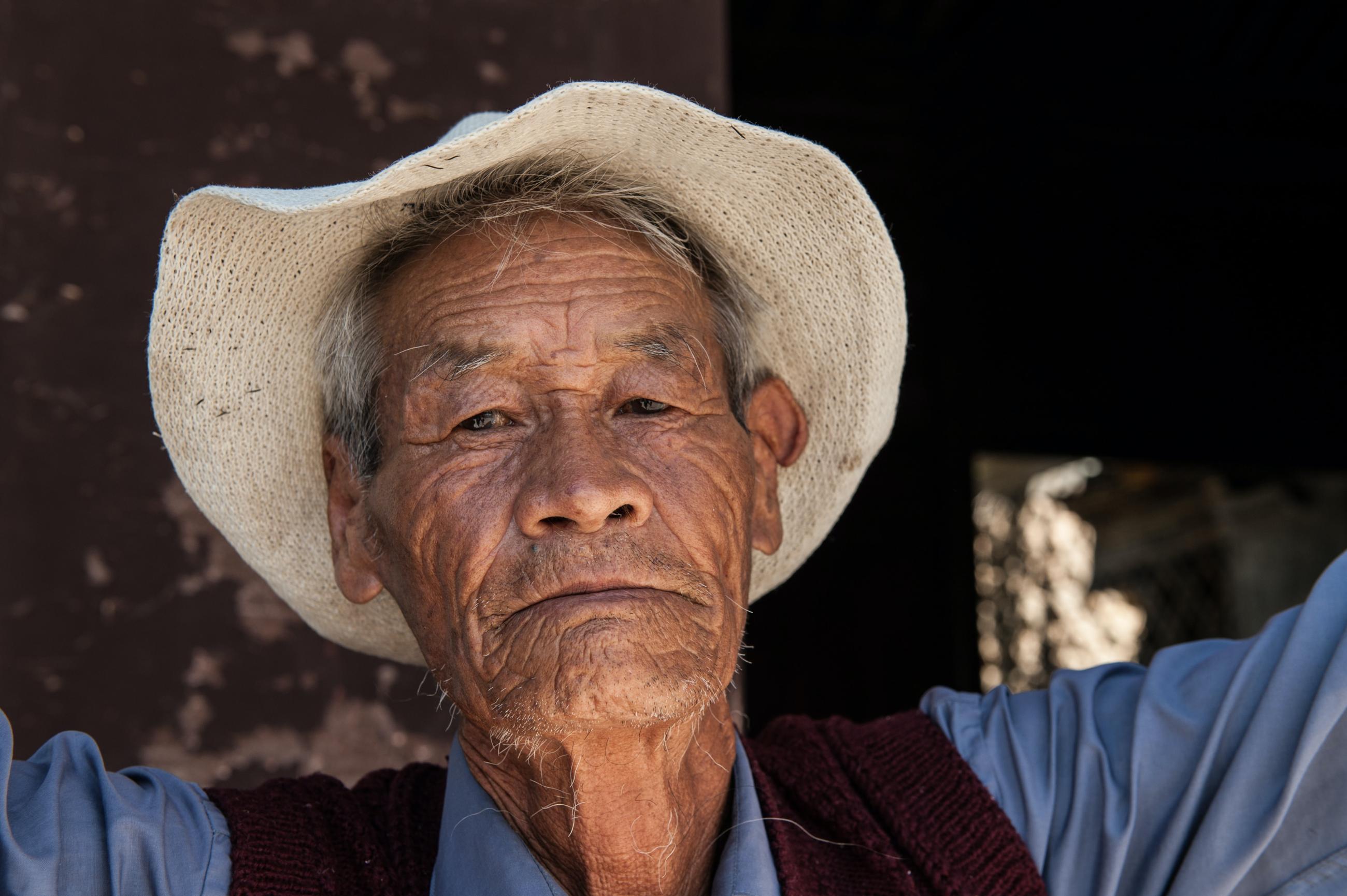 Older man with hat and vest