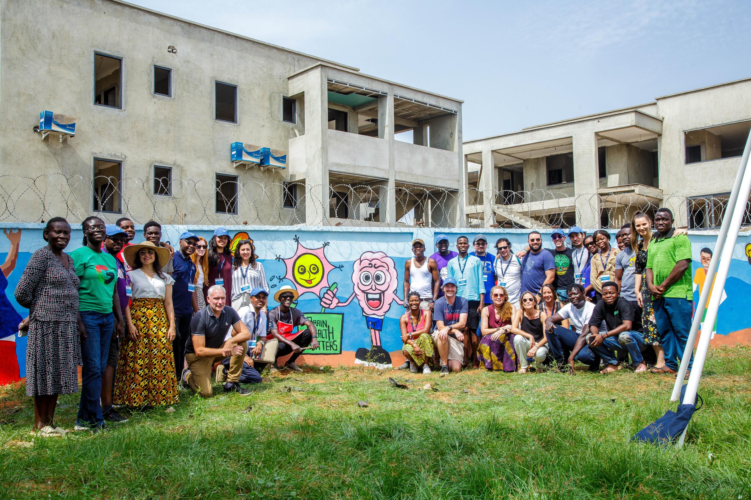GBHI and Agape Academy Members gather in front of mural in Accra, Ghana