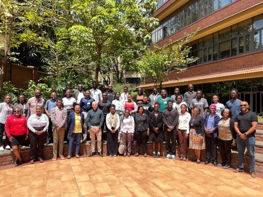 Large group of BRIDGE-AFRICA collaborators standing together outside on the Aga Khan University campus in Nairobi.