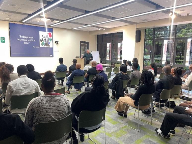 Victor Valcour giving a presentation to clinicians and trainees seated in a lecture room at Aga Khan University.