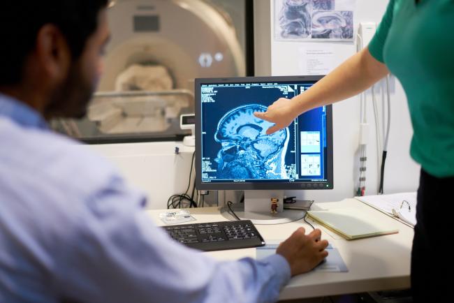 lady pointing to a scan of the brain