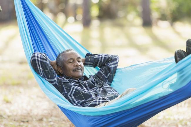 Old black man sleeping in a hammock