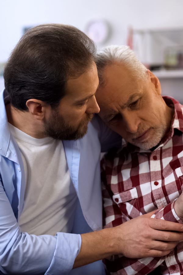 Adult son comforting father