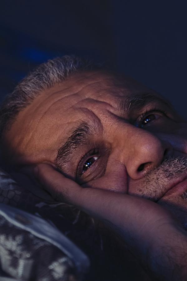 Older man awake in bed