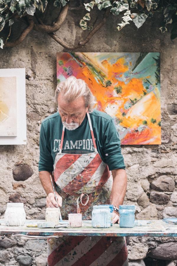 older man painting at table