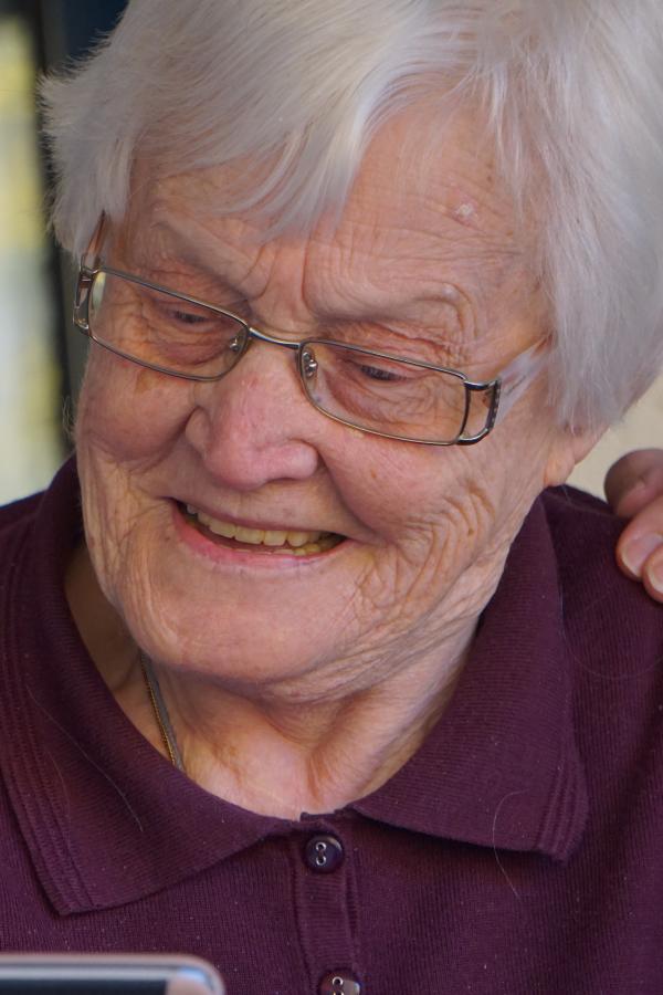 Caregiver and older woman looking at mobile phone screen