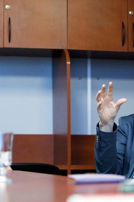 Two men, one younger in white coat, engage in discussion