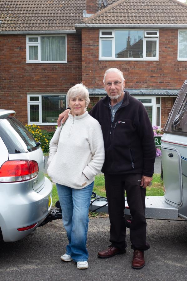 Older man and woman outside house