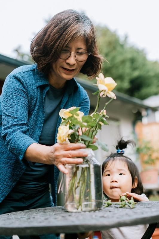 Grandmother Puts Flower in Vase