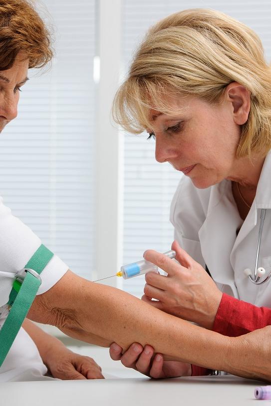 Doctor with syringe is taking blood for test