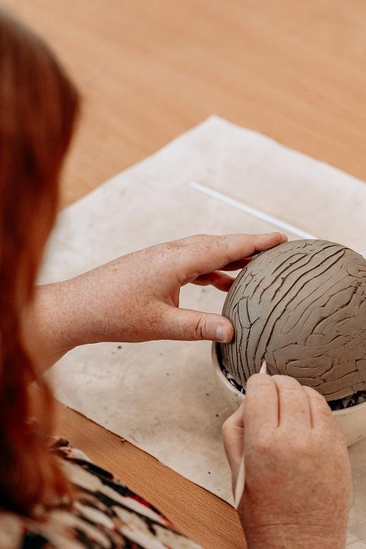 woman sculpting a brain with clay