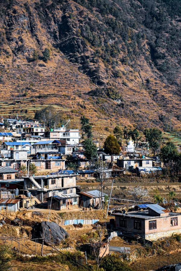 A small mountain village in Nepal with houses scattered along terraced hillsides.