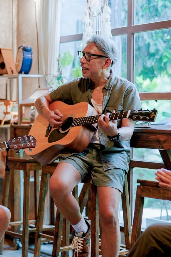 group of older people playing guitar and singing