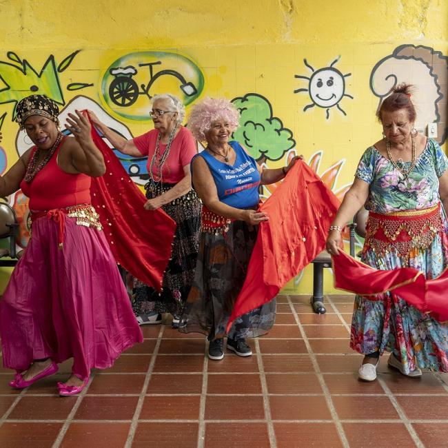 Group of ladies in colorful outfits dancing