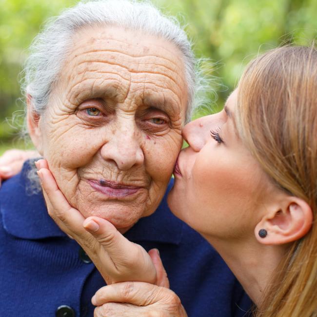Picture of a senior woman with her caring granddaughter