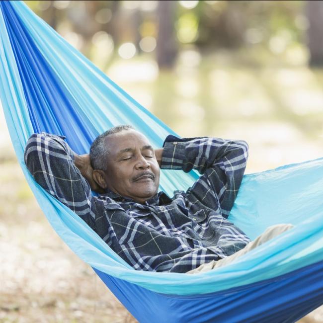 Old black man sleeping in a hammock