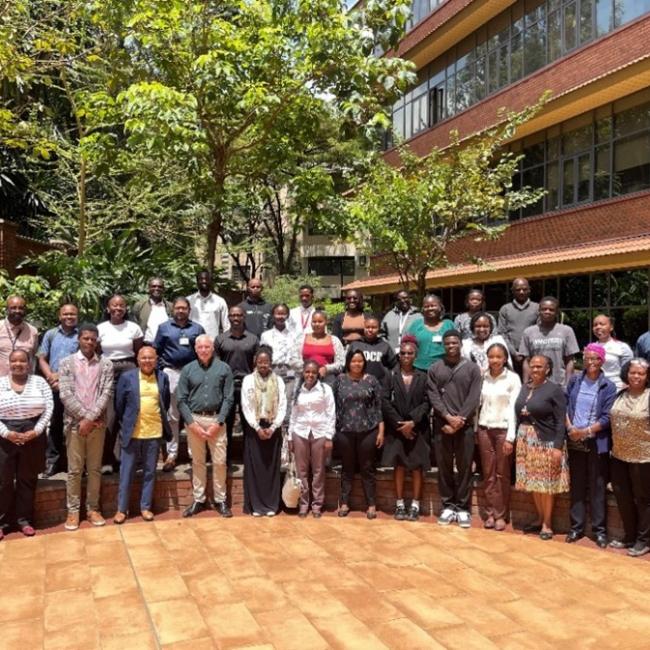 Large group of BRIDGE-AFRICA collaborators standing together outside on the Aga Khan University campus in Nairobi.