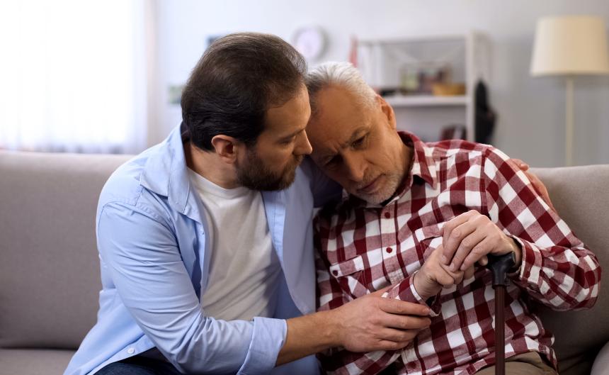Adult son comforting father