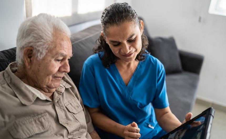 nurse and older adult using tablet