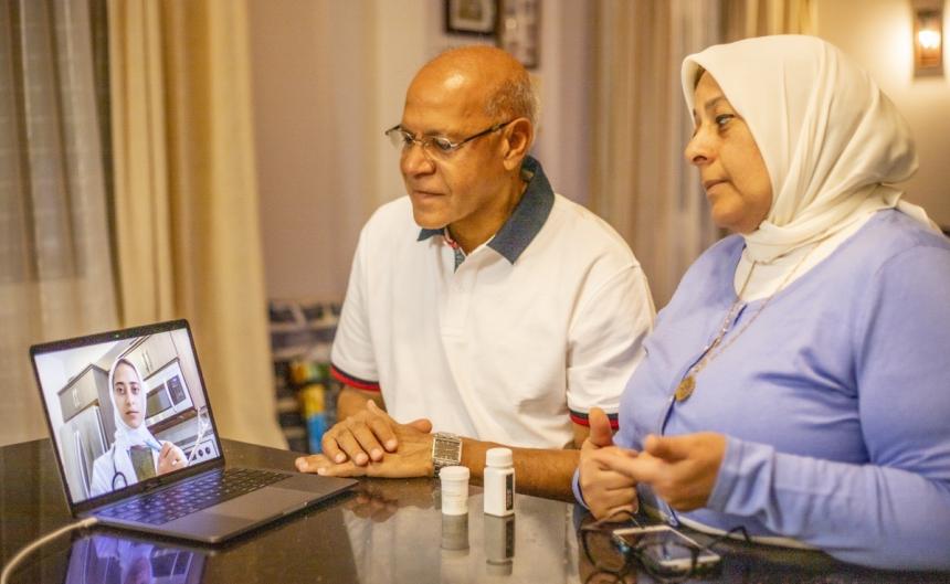 Arab doctor consulting virtually with older couple