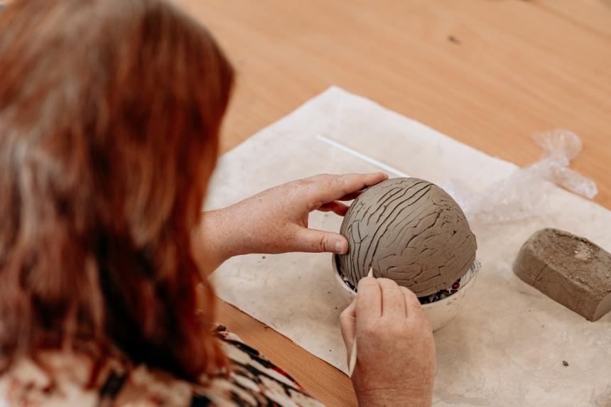 woman sculpting a brain with clay
