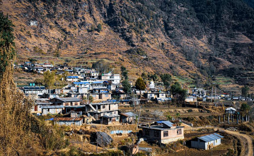 A small mountain village in Nepal with houses scattered along terraced hillsides.