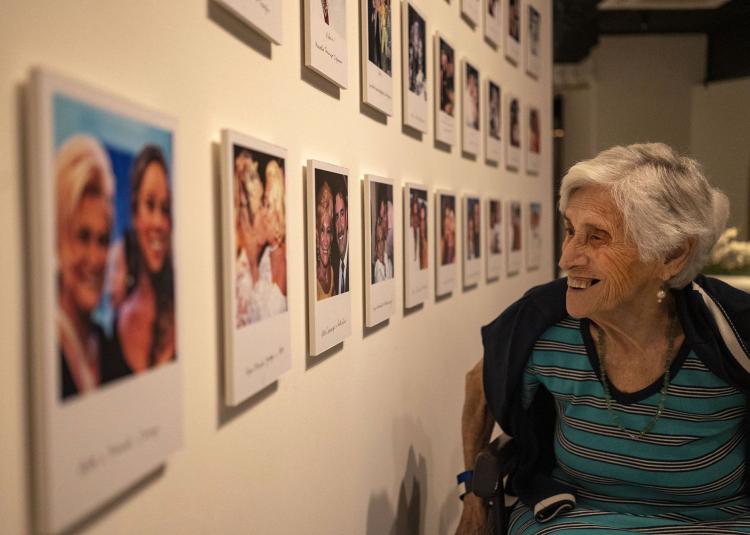 Older woman in wheelchair looking at art exhibit, photo taken by Atlantic Senior Fellow Alex Kornhuber
