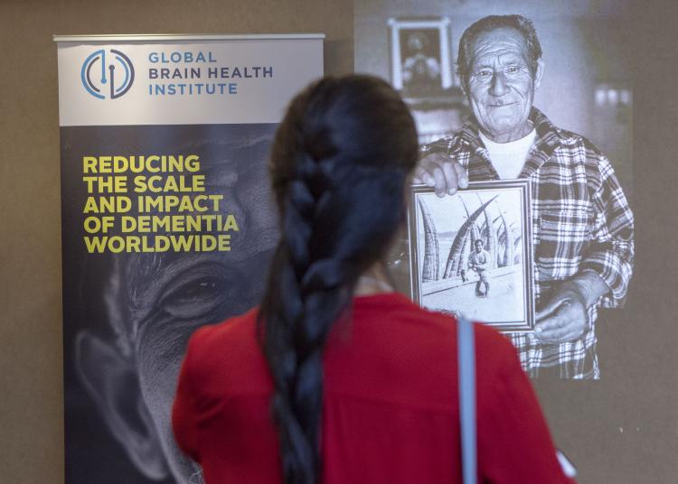 Person looking at GBHI poster and Alex photo