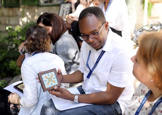 A faculty member displays a piece of art