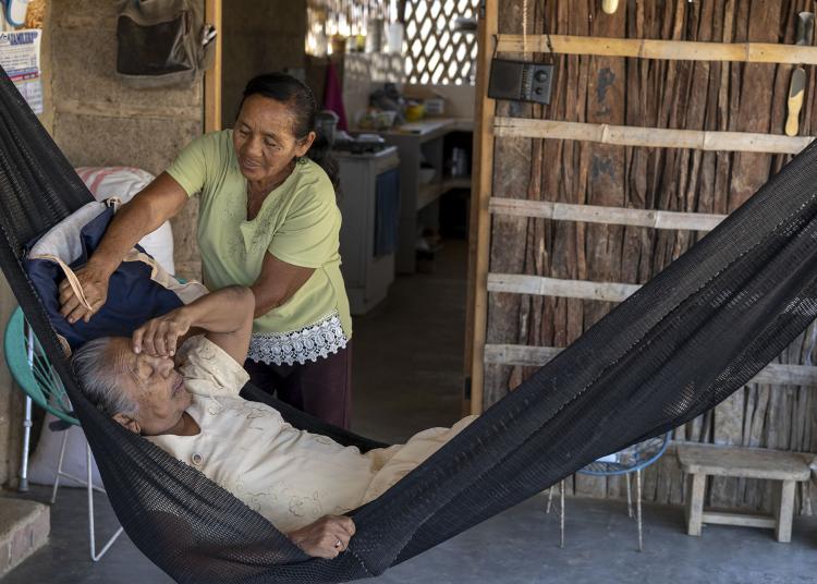 Woman caring for other woman in hammock