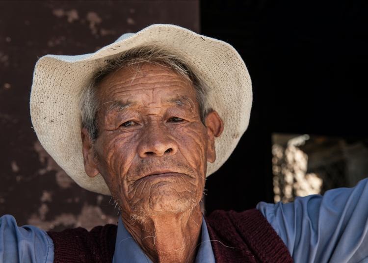 Older man with hat and vest