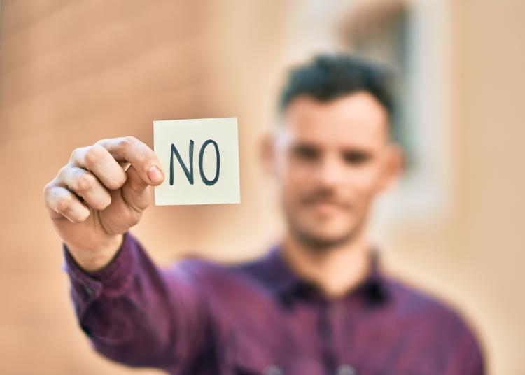 Man holding a saying that says &quot;no&quot;