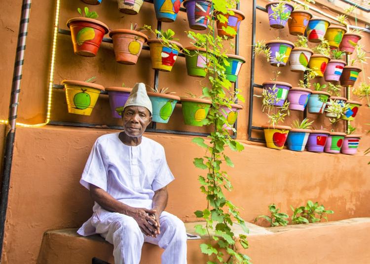 Bloom garden man with display wall of painted flower pots