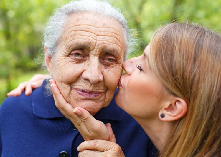 Picture of a senior woman with her caring granddaughter