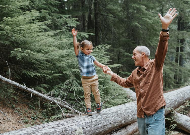 Joyful little girl enjoying nature with her playful grandfather