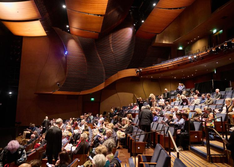 Audience members sit and chat inside the theater before the UnRavelled performance begins.