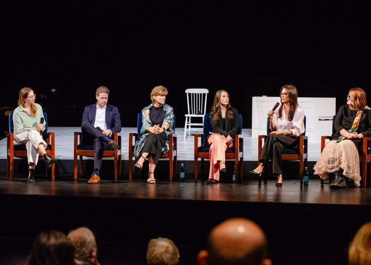 Six panelists sit on stage talking about FTD at the UnRavelled event, with one speaking into a microphone.