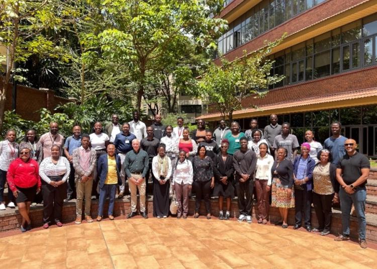 Large group of BRIDGE-AFRICA collaborators standing together outside on the Aga Khan University campus in Nairobi.