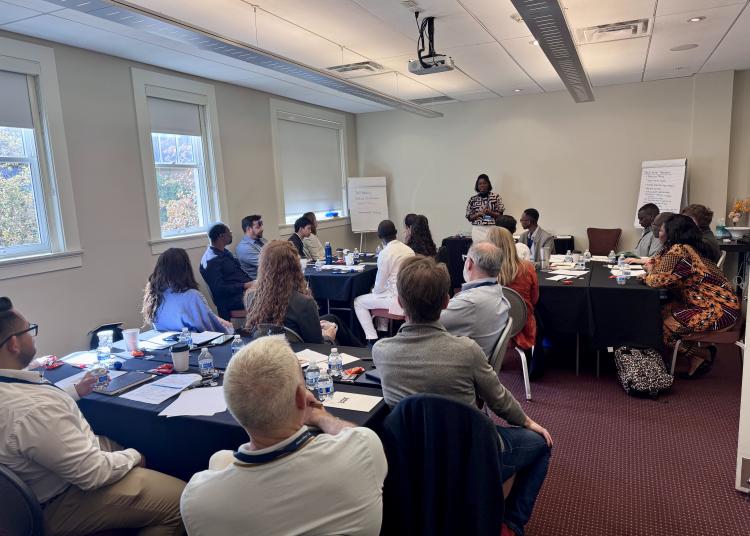 Atlantic Fellows sit in a meeting room, listening to a speaker during a group discussion.