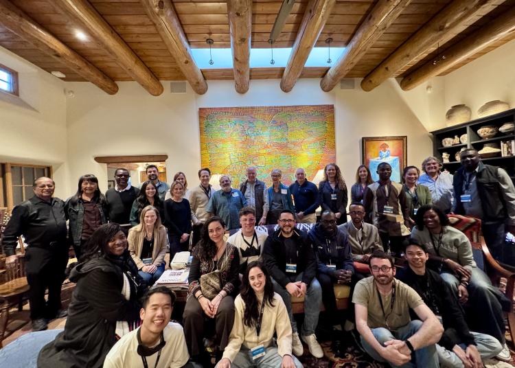 A large group of GBHI community members pose together indoors during the New Mexico retreat.