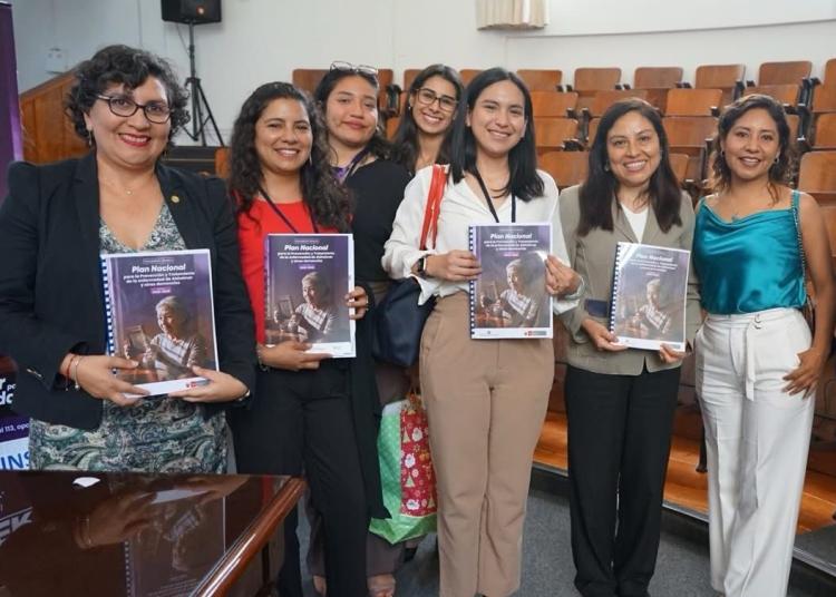 Researchers and partners hold copies of Peru’s National Dementia Plan during a gathering in Lima.