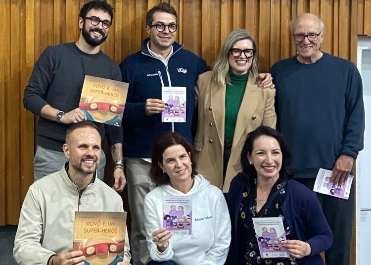 Atlantic Fellows and GBHI leaders pose together holding children's brain health books and educational booklets.
